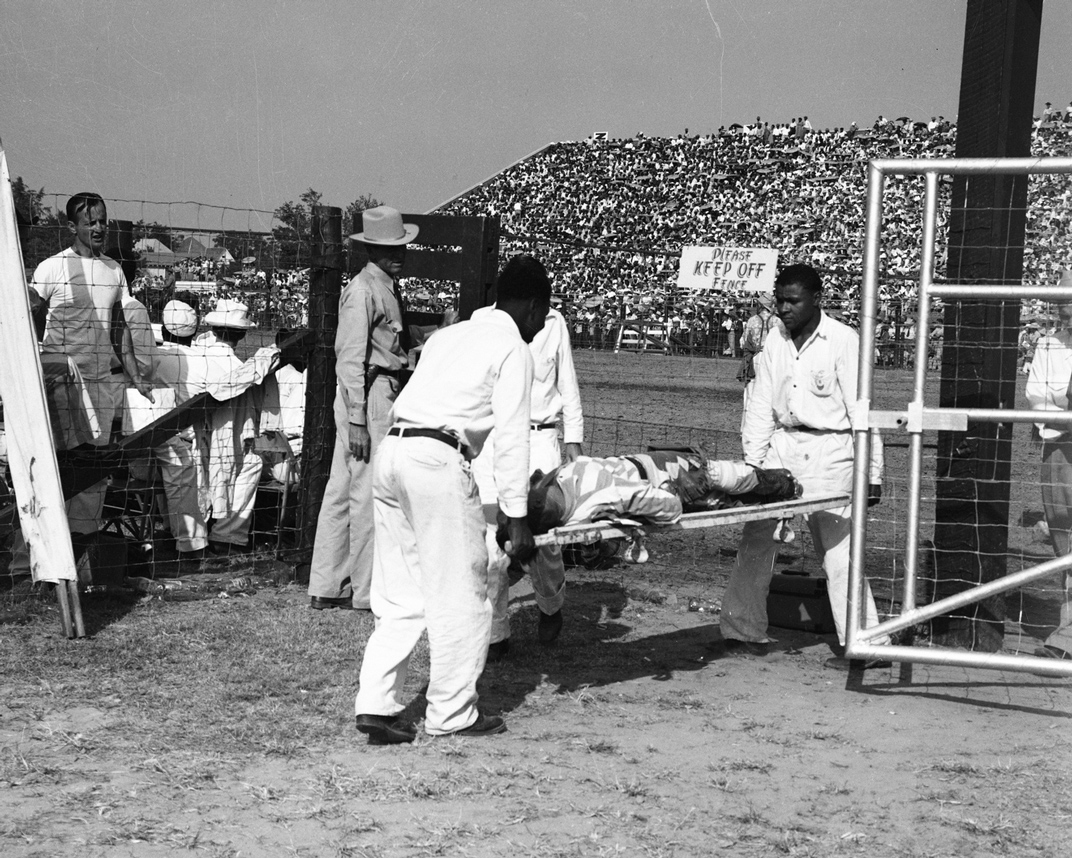 An injured cowboy is taken away by stretcher in 1952